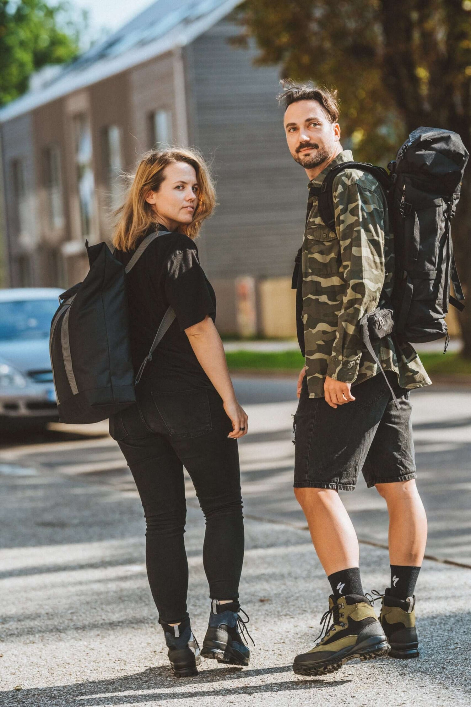 Two people with backpacks walking outdoors, showcasing European fashion available on USMIH Grid. Purchase with cards or cryptocurrency.