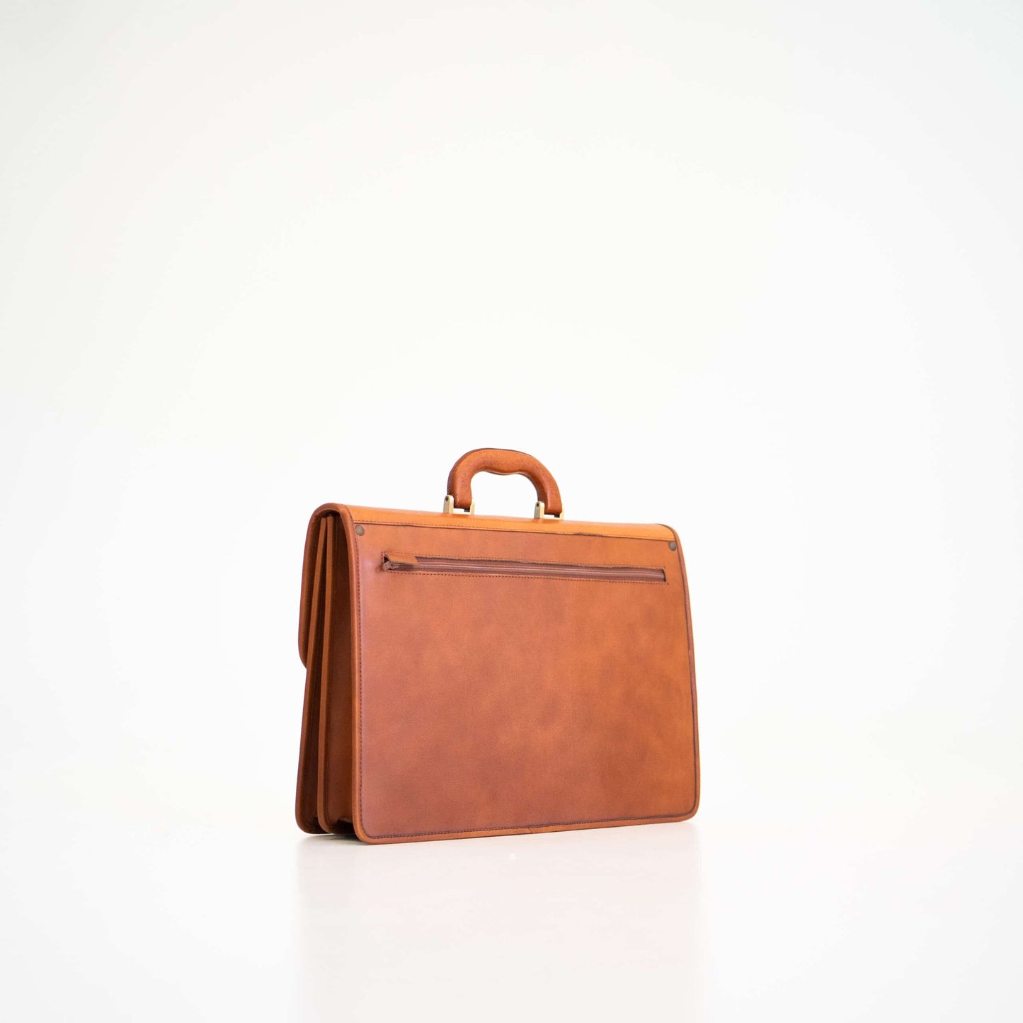 Cognac leather briefcase No. 99 with dual compartments and A4-size zip pocket, handcrafted in Tartu, Estonia.