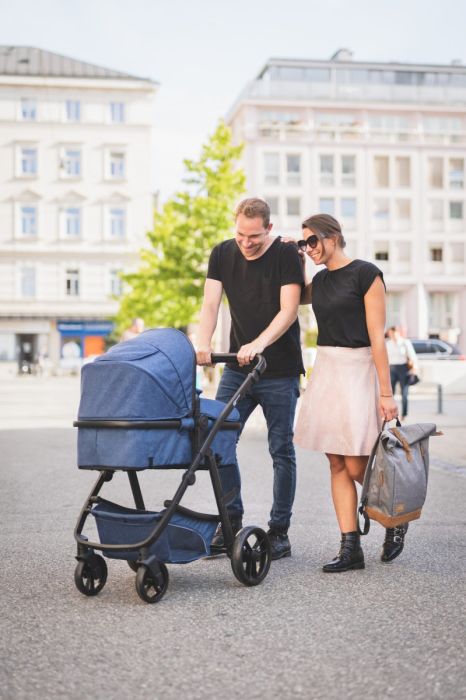 Couple walking with baby stroller and Fillikid Diaper Backpack Berlin, available in USMIH Grid, card and Bitcoin payments.