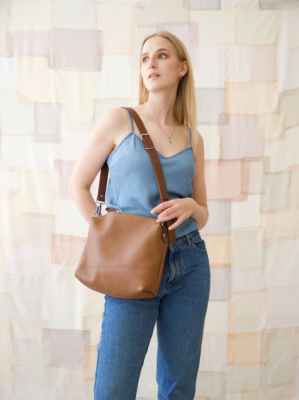 Camel brown ROFIN leather handbag on model in blue top, available on USMIH Grid, a popular European marketplace. Purchase with cards or Bitcoin.