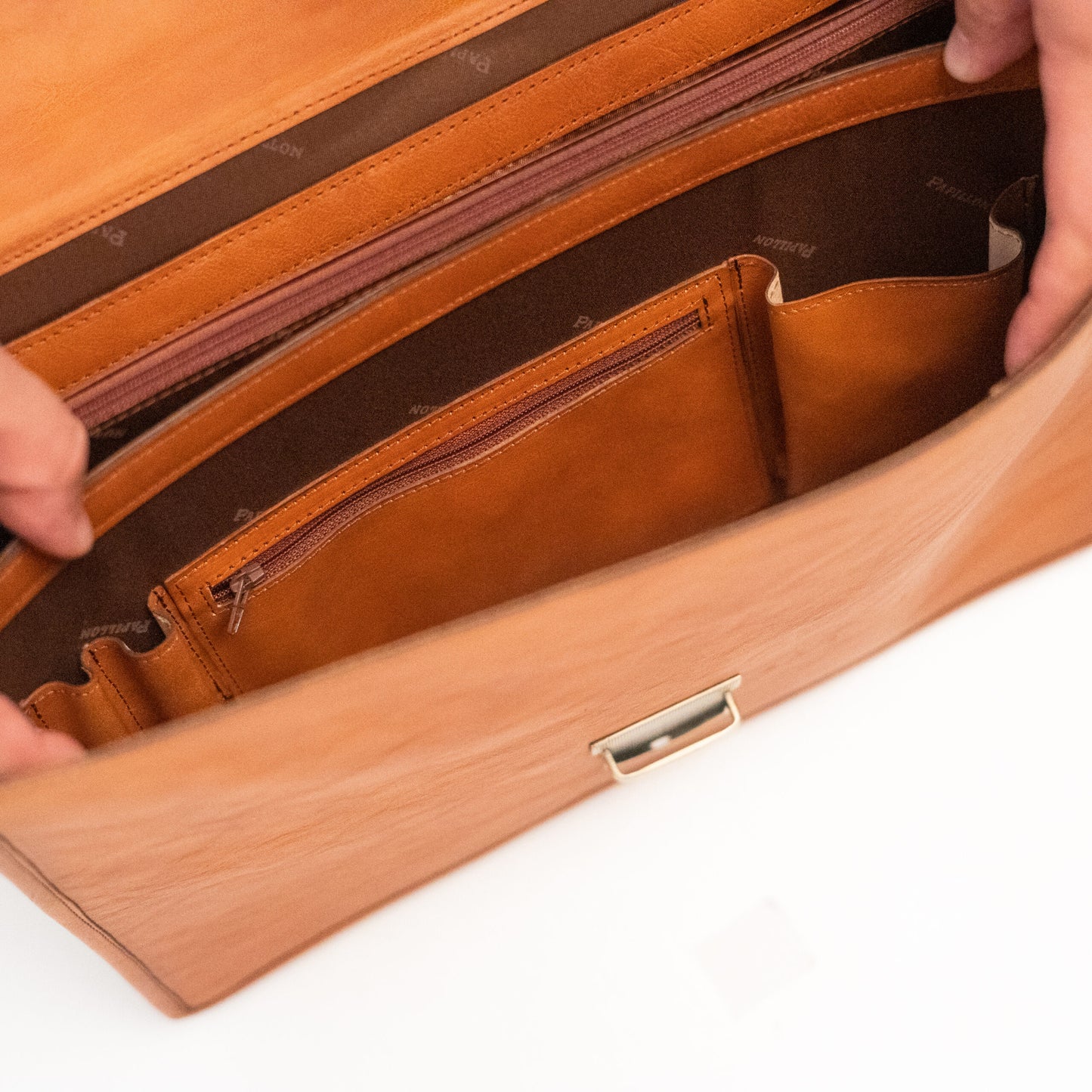 Interior view of Leather Briefcase No. 99 - Cognac, showing dual compartments and an A4-size zip pocket, handcrafted from genuine leather.