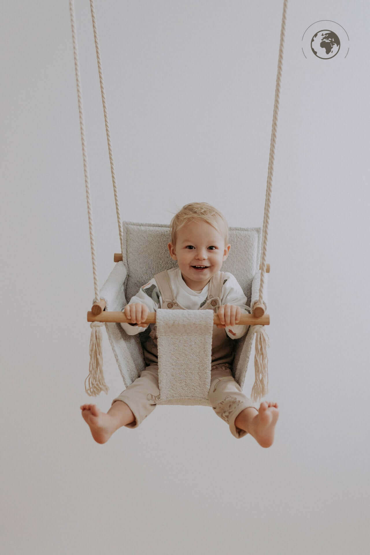 Toddler in BaBi Baby Swing Bouclé Ice Grey made from recycled materials, available on USMIH Grid with card and cryptocurrency payments.