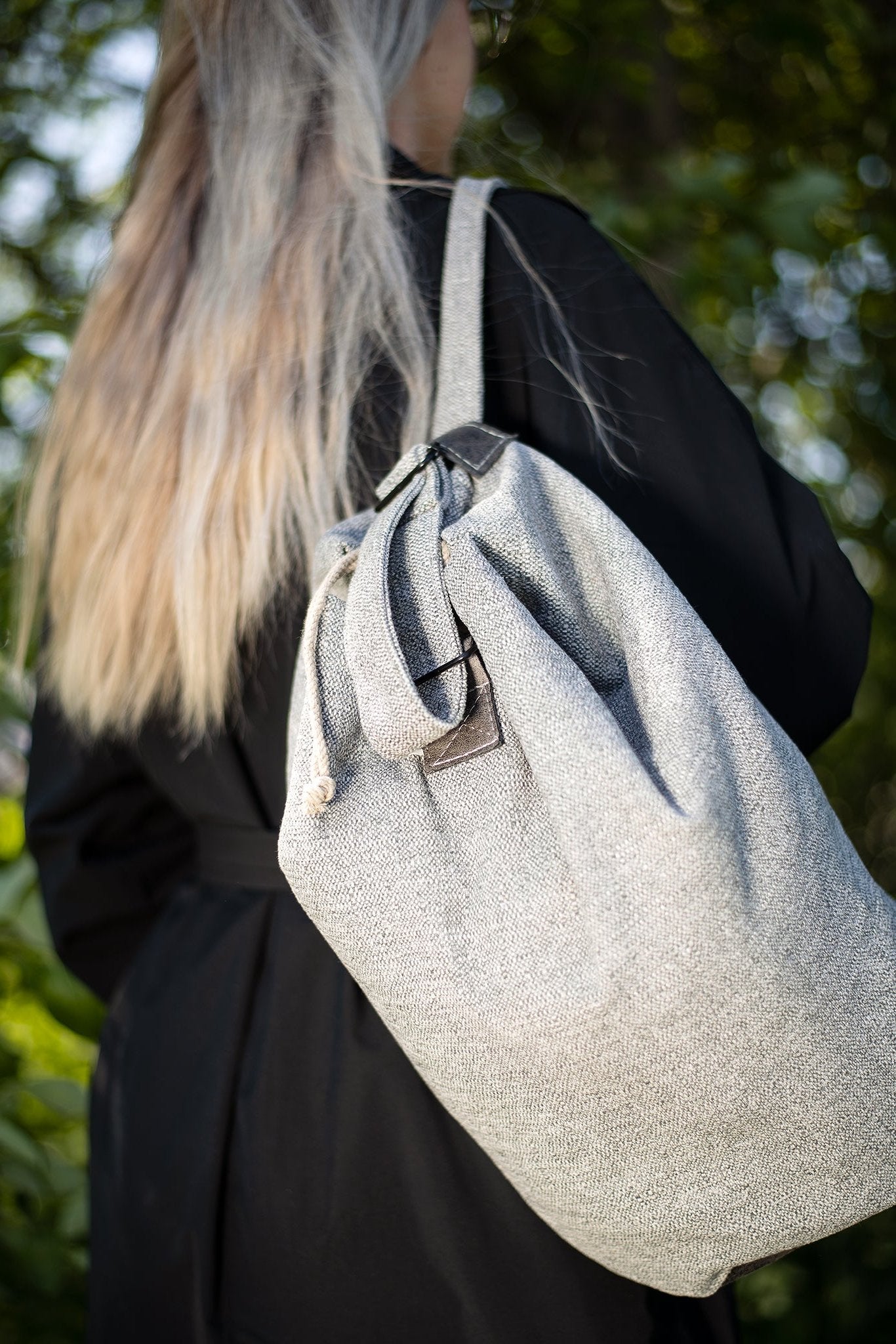 Woman wearing a green Märss upcycled bag made of durable leftover fabric with faux leather details, showcasing eco-friendly fashion.