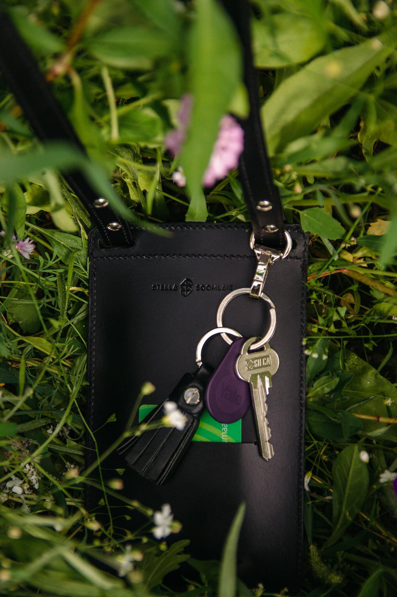 Black By Your Side phone bag with keychain in grass, ideal unique gift for men, purchase with Bitcoin on USMIH Grid.