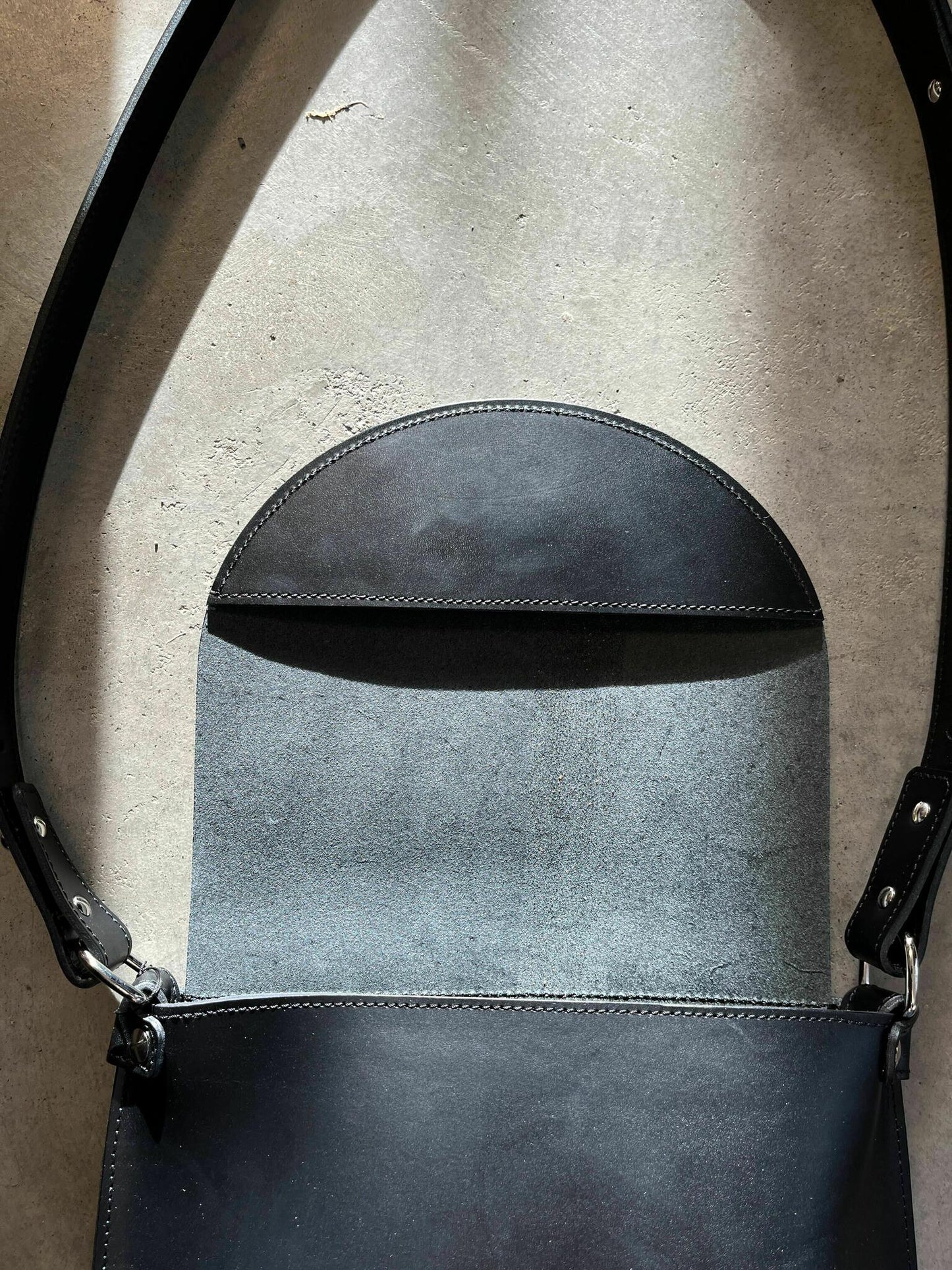 Classic leather handbag open view with adjustable strap and metal plate closure, available for online purchase on USMIH Grid.