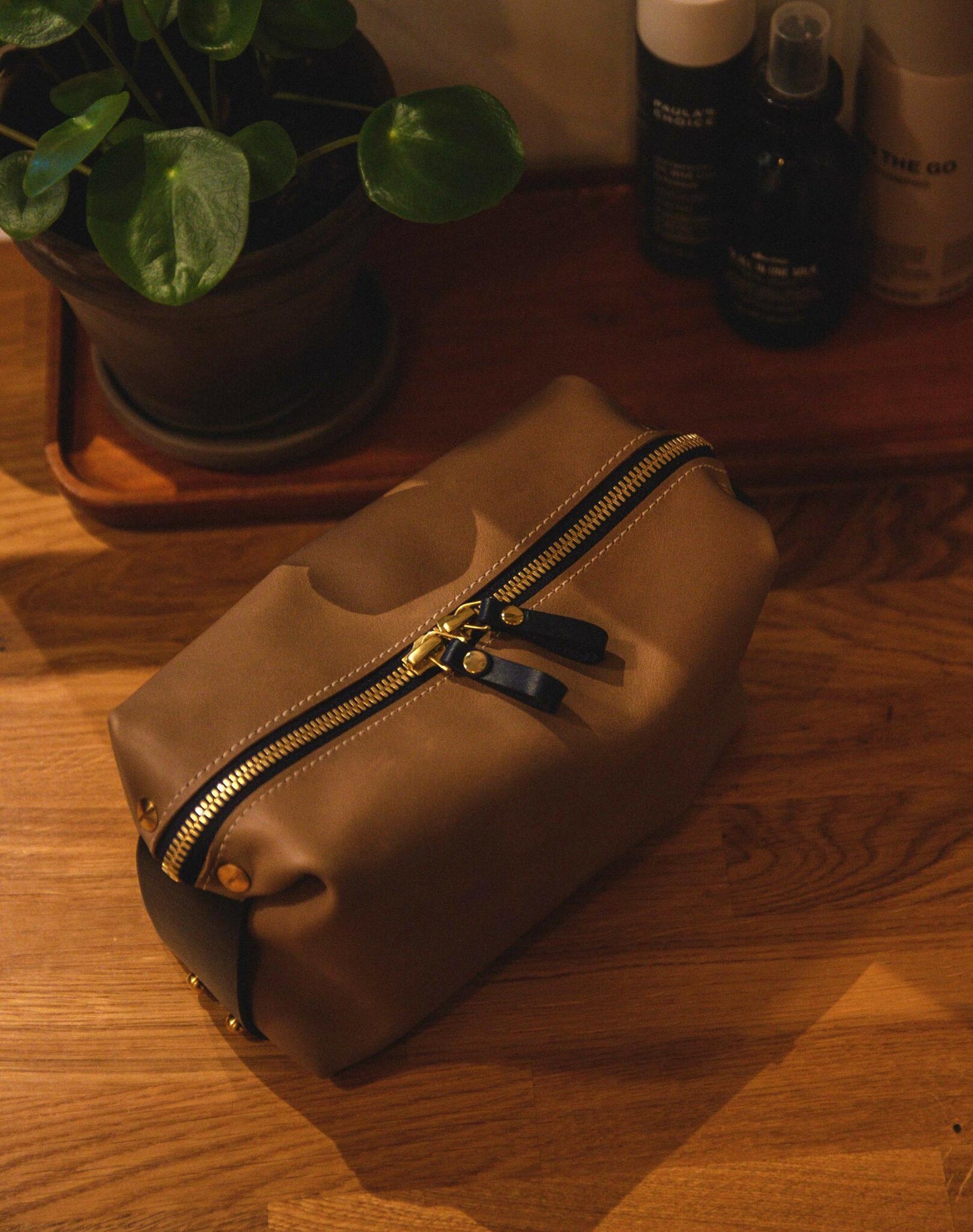 Large luxury leather toiletry bag on a wooden surface, ideal travel accessory, available at USMIH Grid. Pay online with card or crypto.