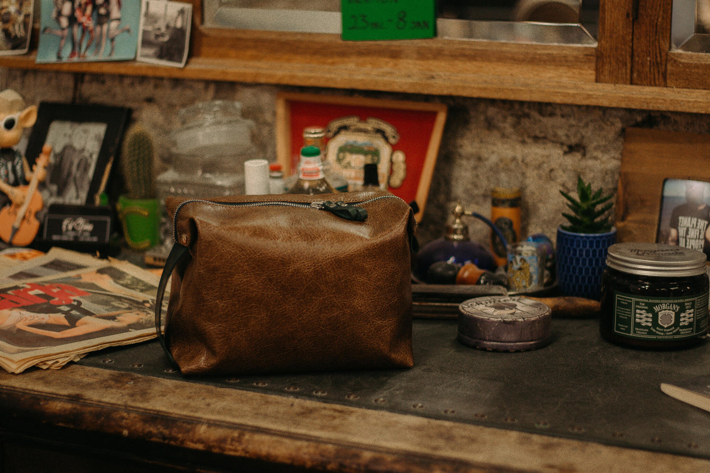 Small leather toiletry bag on a vintage wooden shelf, ideal for travel or home use, available on USMIH Grid where you can pay with Bitcoin.