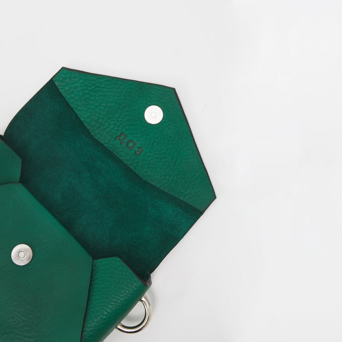 Green handmade leather envelope bag with silver magnet closure and embossed logo, available on USMIH Grid. Pay with card or cryptocurrency.