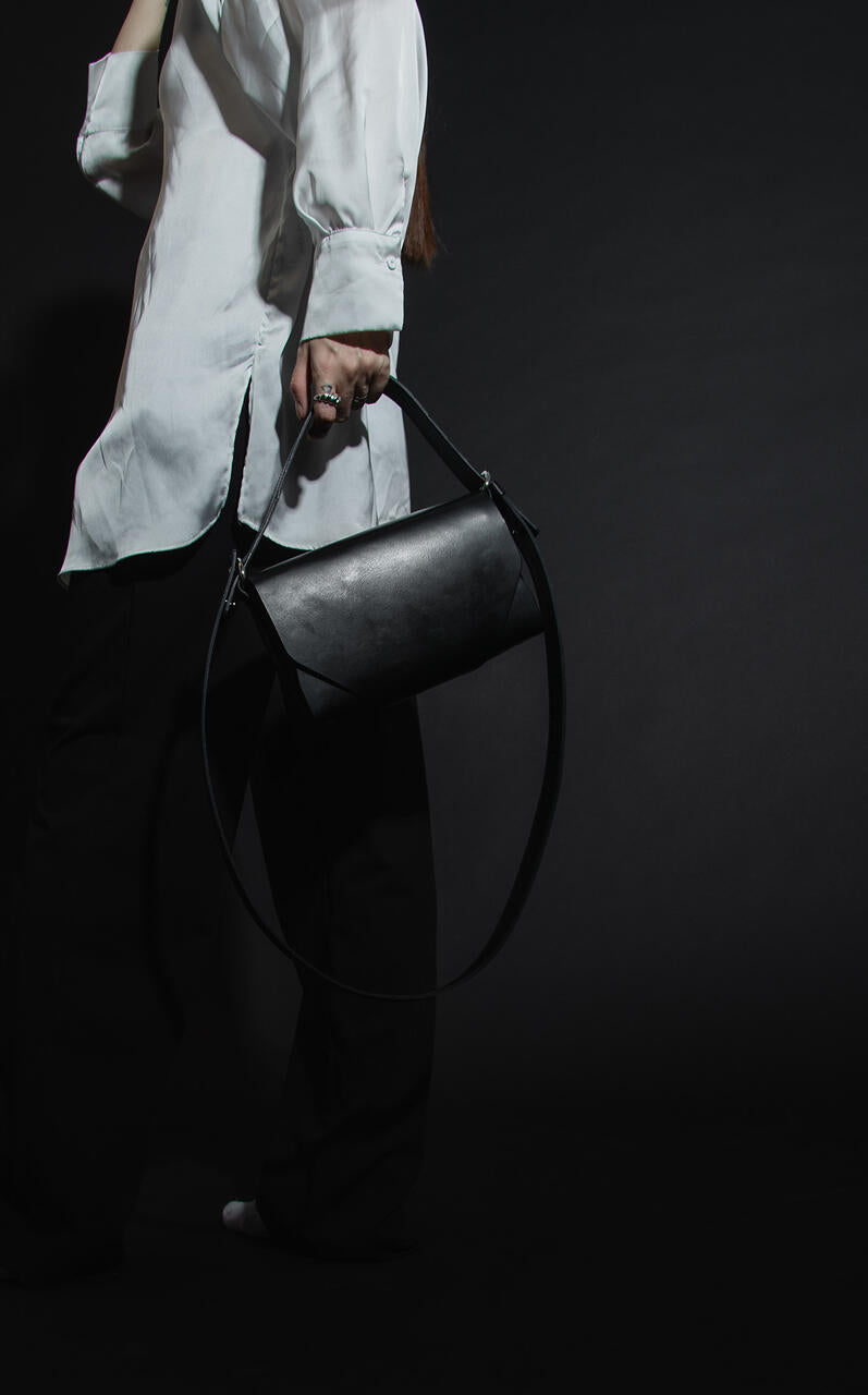 Sleek black leather fanny bag worn as shoulder bag, available on USMIH Grid. Buy online with card or crypto like Bitcoin.