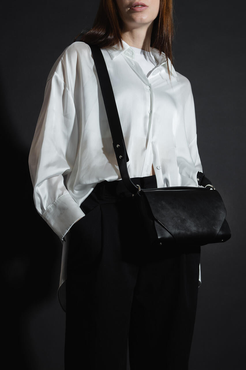 Woman wearing Stella Soomlais black leather fanny bag as a shoulder bag, featured on USMIH Grid for online shopping with crypto options.