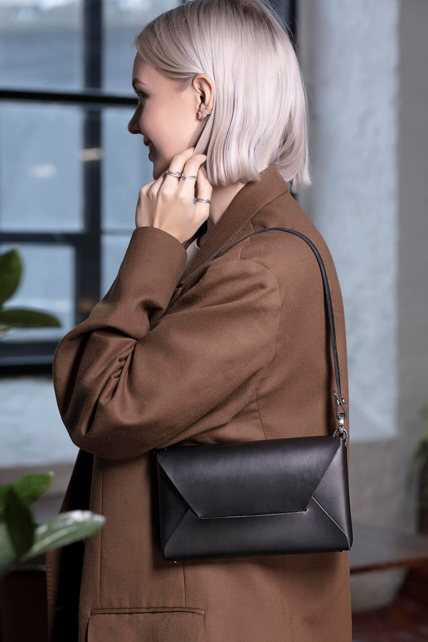 Woman with Stella Soomlais black leather evening bag, available on USMIH Grid, a prime European marketplace accepting Bitcoin payments.