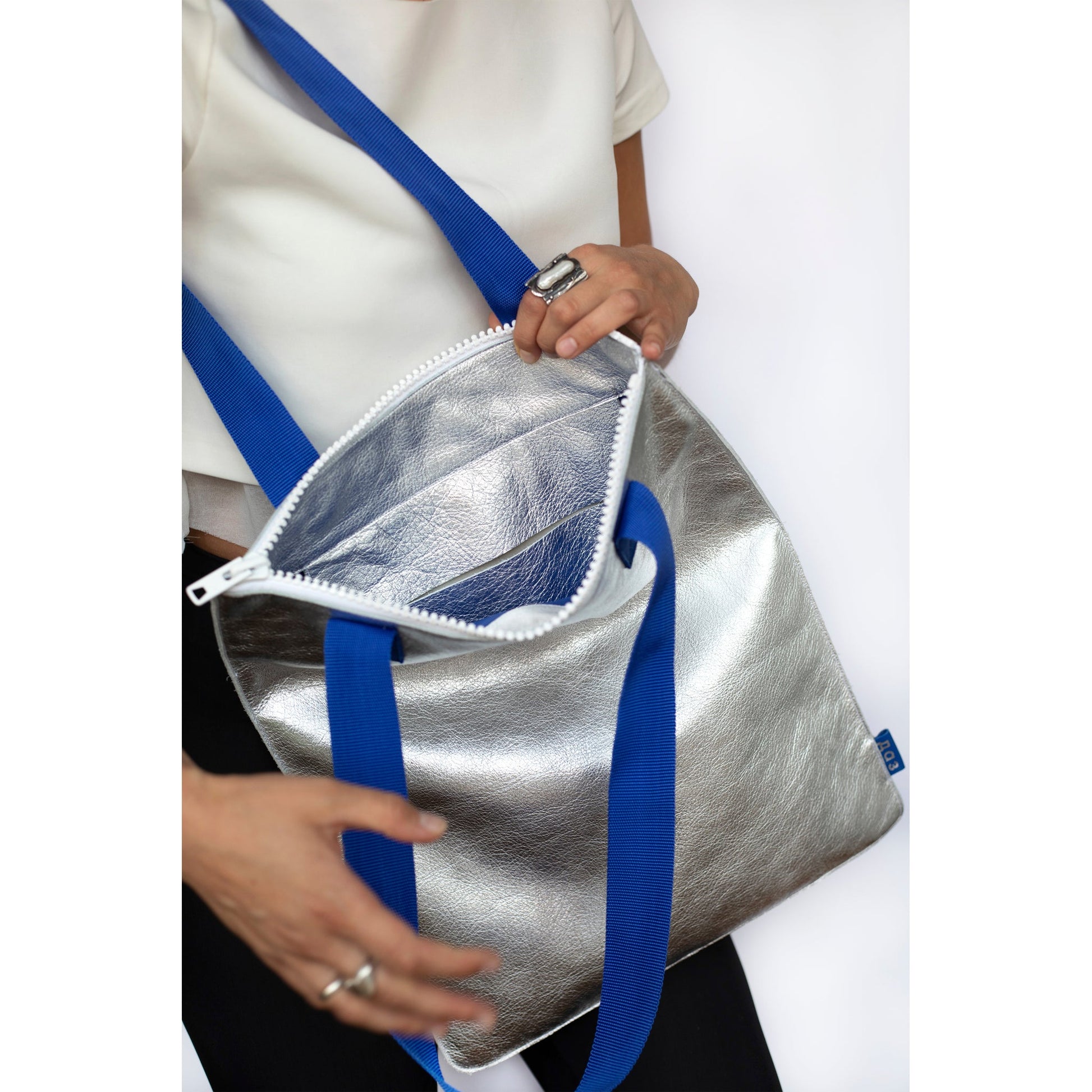 Silver handmade leather tote with blue straps and white zipper, available on USMIH Grid. Buy with card or cryptocurrency.