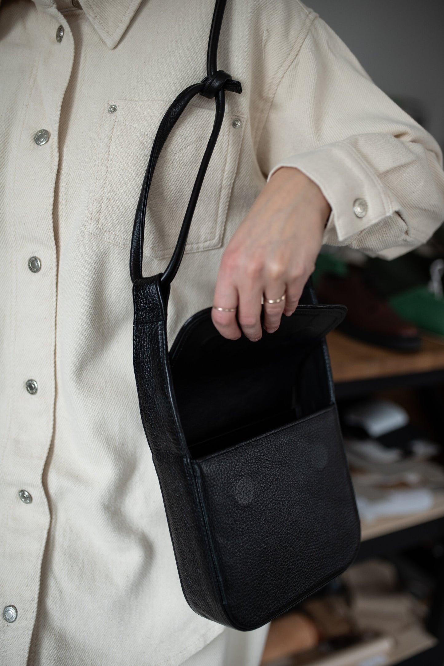 Minimalist unisex black crossbody bag MUSA with adjustable strap and magnetic clasps. Perfect luxury gift idea.