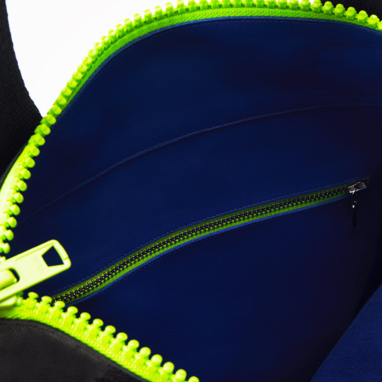 Interior view of black leather tote with neon green zipper, blue lining. Available on USMIH Grid. Purchase with card or cryptocurrency.