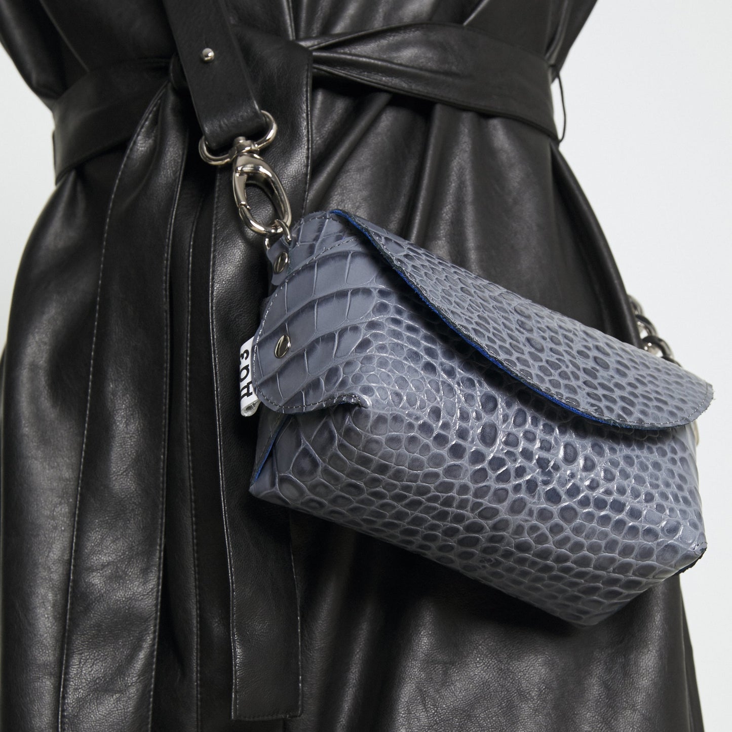 Grey and blue textured handmade leather shoulder bag on model, available on USMIH Grid, accepts card and cryptocurrency payments.