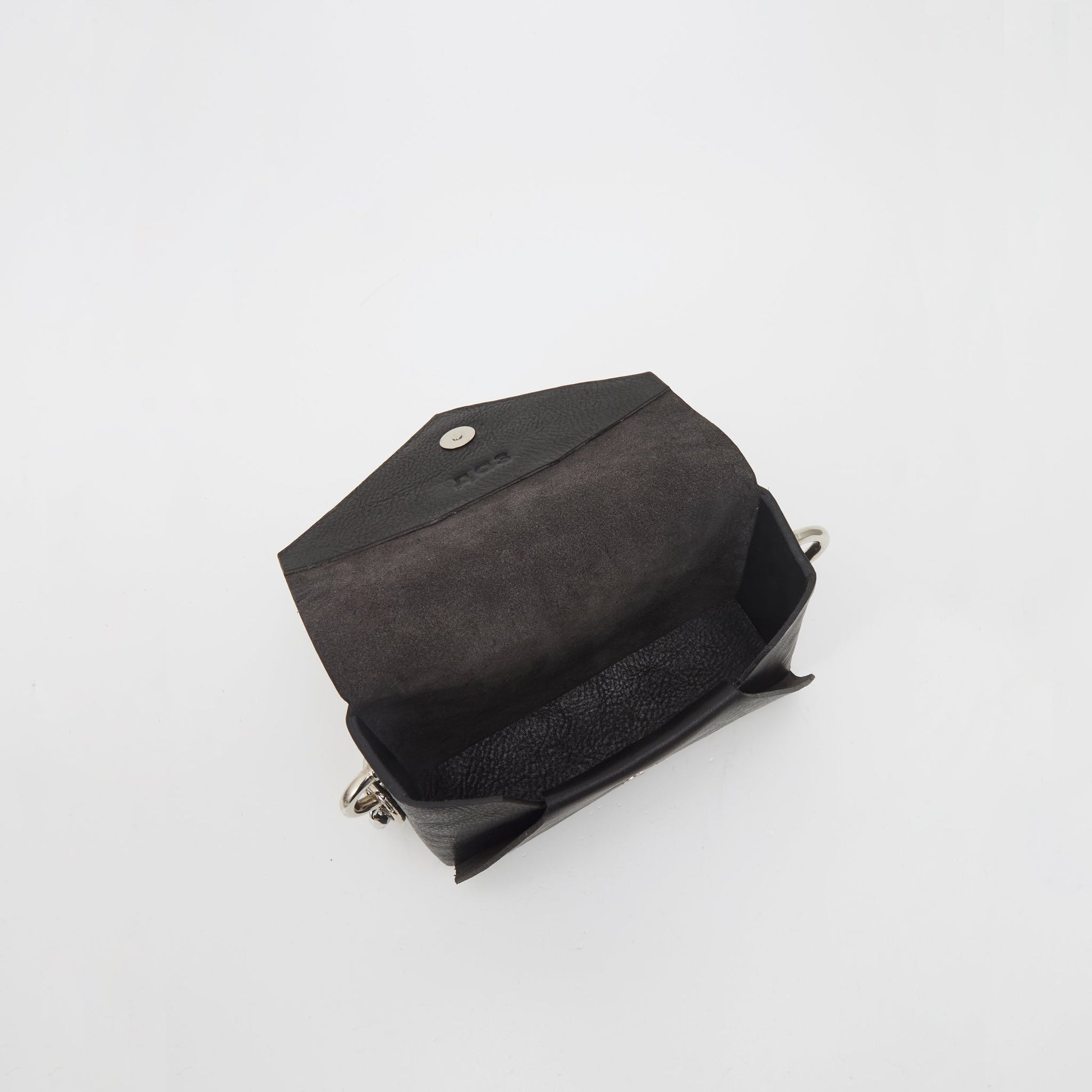 Handmade black leather envelope bag with open flap, showcasing raw leather interior and embossed logo, available on USMIH Grid for card and crypto payments.